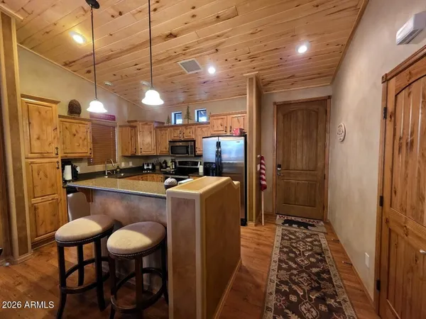 a kitchen with stainless steel appliances granite countertop a sink a counter space and a refrigerator