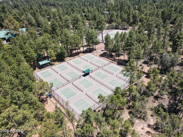 an aerial view of residential house with outdoor space and trees all around