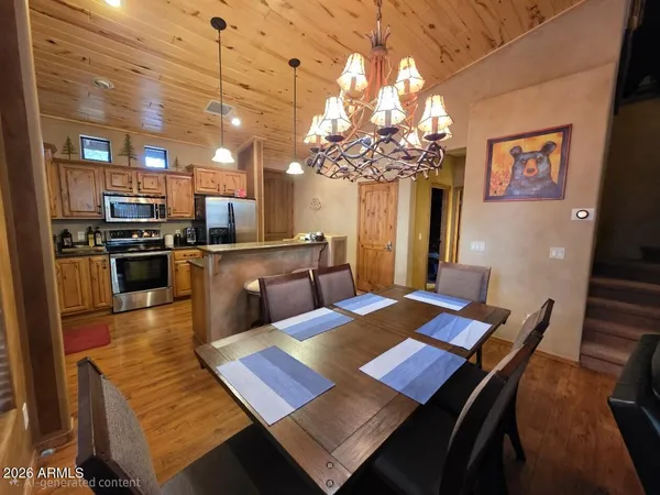 a view of a dining room with furniture a chandelier and wooden floor