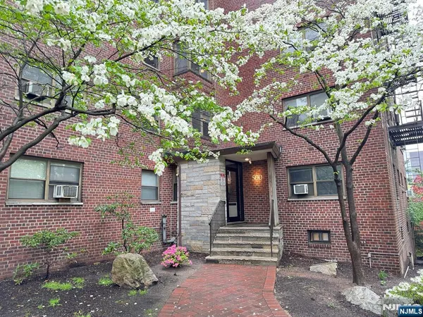 a front view of a house with a tree