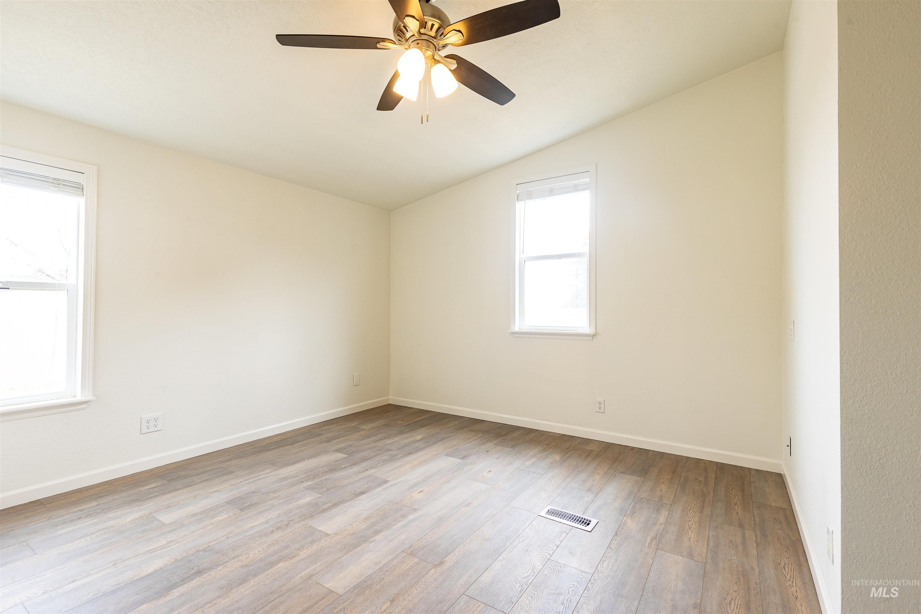 17028 Lower Pleasant Ridge Road Caldwell, ID 83607 - Photo 12 of 21 Room featuring wood-finish flooring, white baseboards, and neutral wall tones
