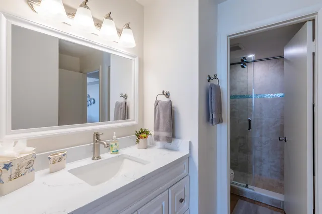 a bathroom with a sink vanity granite shower and a mirror