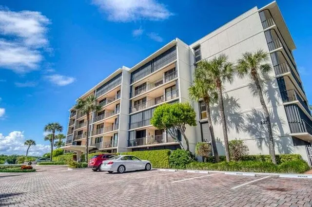 a tall buildings with small trees in front of it