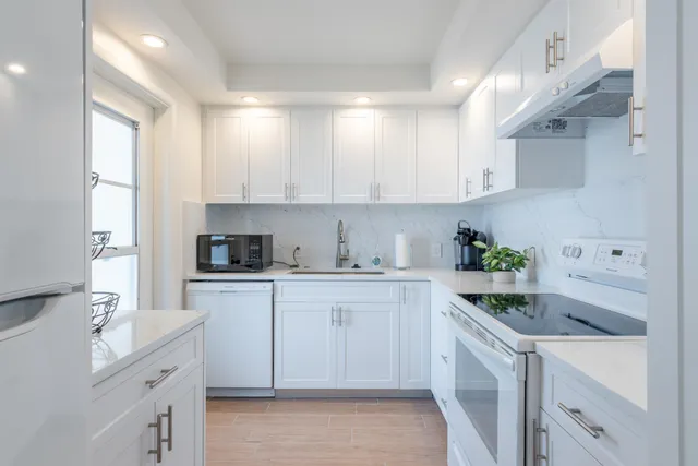 a kitchen with cabinets appliances a sink and a counter top space