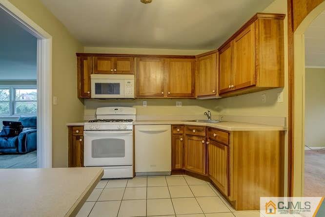 52 Sturgis Road Edison, NJ 08817 - Photo 18 of 22 a kitchen with stainless steel appliances granite countertop a stove a sink and a microwave