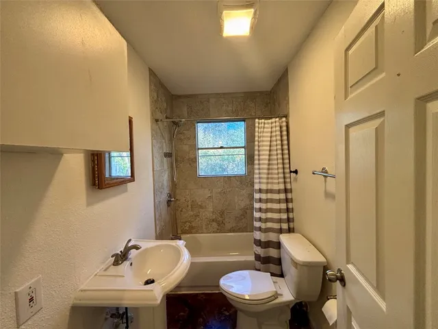 a bathroom with a sink a toilet a mirror and shower