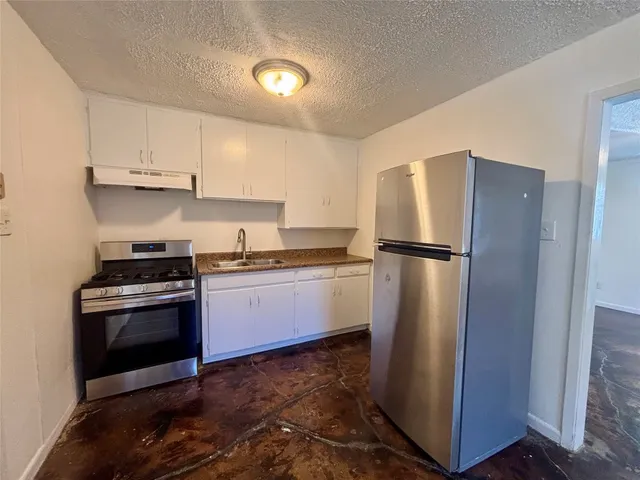 a kitchen with a refrigerator stove and white cabinets