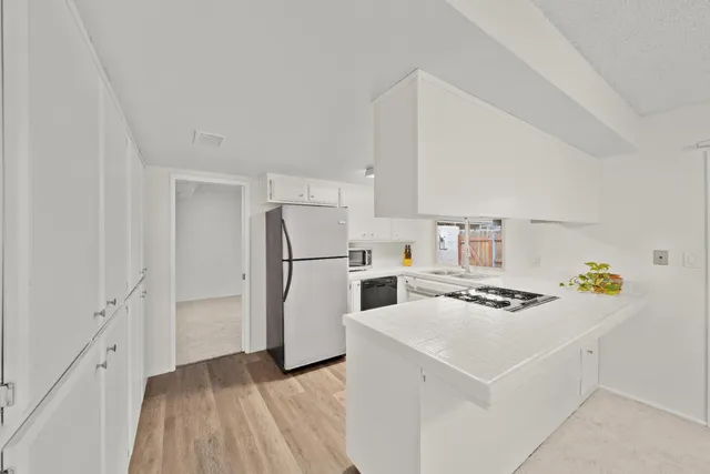 a kitchen with stainless steel appliances a sink stove and cabinets