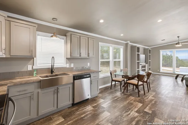 a kitchen with sink cabinets and dining table chair