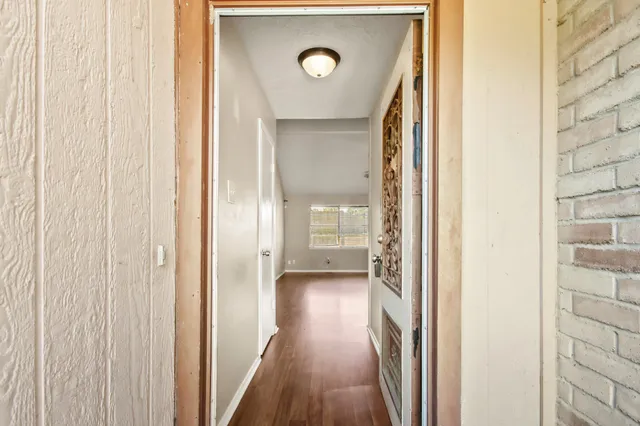 a view of a hallway with wooden floor