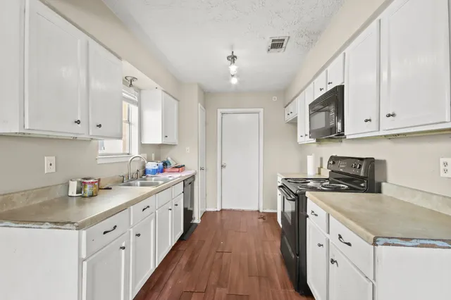 a kitchen with a sink stove and cabinets