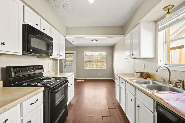 a kitchen with stainless steel appliances a sink dishwasher stove microwave and cabinets