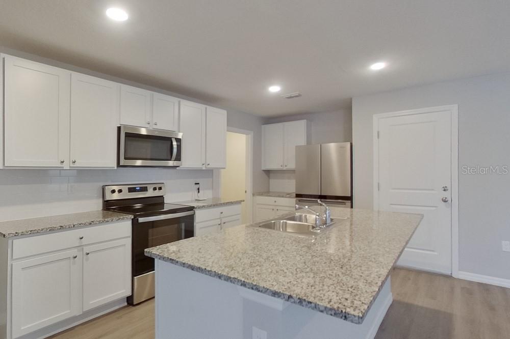 4397 Southwest 85th Lane Ocala, FL 34476 - Photo 5 of 23 a kitchen with stainless steel appliances granite countertop a sink stove and refrigerator