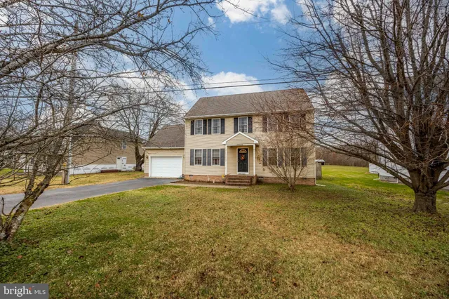 a view of a house with a large tree and a yard