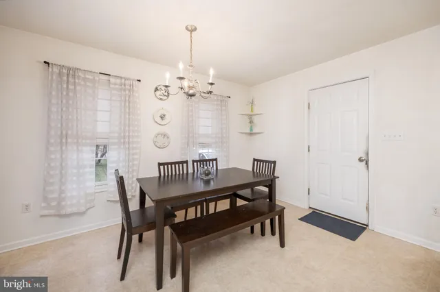 a view of a dining room with furniture and chandelier