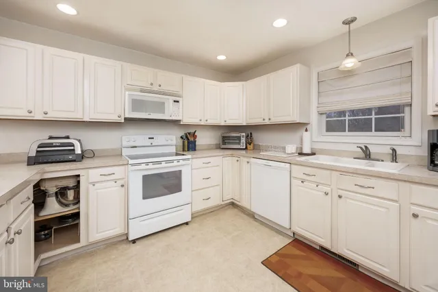 a kitchen with cabinets appliances a sink and a window