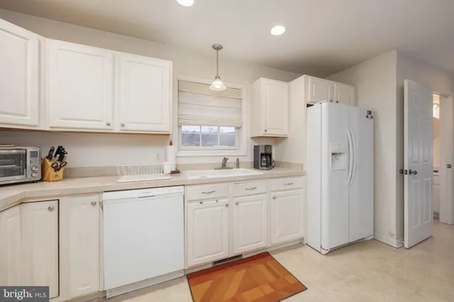 a kitchen with white cabinets and refrigerator