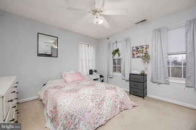 a bedroom with a bed and a refrigerator