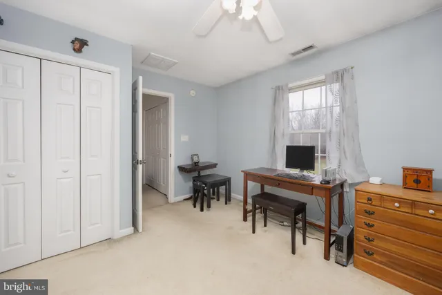 a view of a workspace with furniture and a window