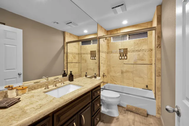 a bathroom with a granite countertop sink toilet and shower