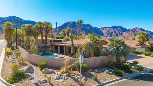 a view of a house with a yard and potted plants