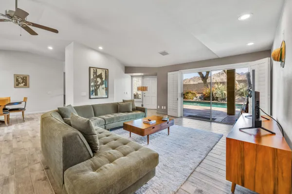 a living room with furniture and floor to ceiling window