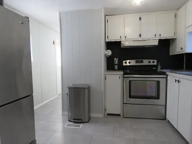 a kitchen with granite countertop white cabinets and stainless steel appliances
