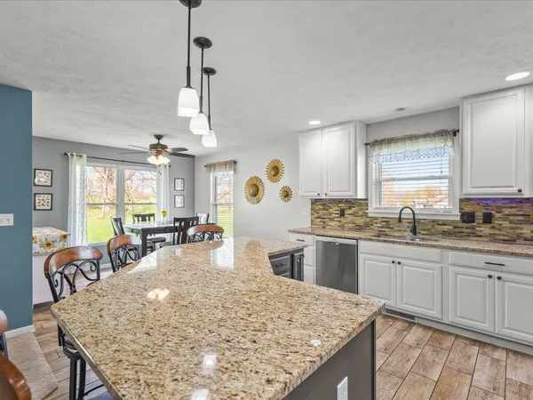 a kitchen with center island table and chairs