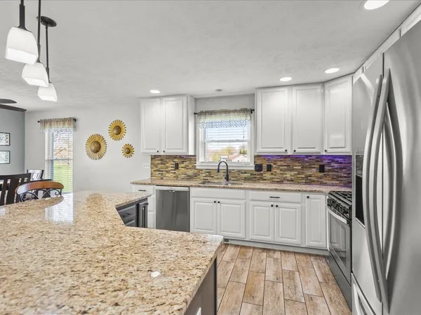 a kitchen with stainless steel appliances granite countertop sink refrigerator and cabinets