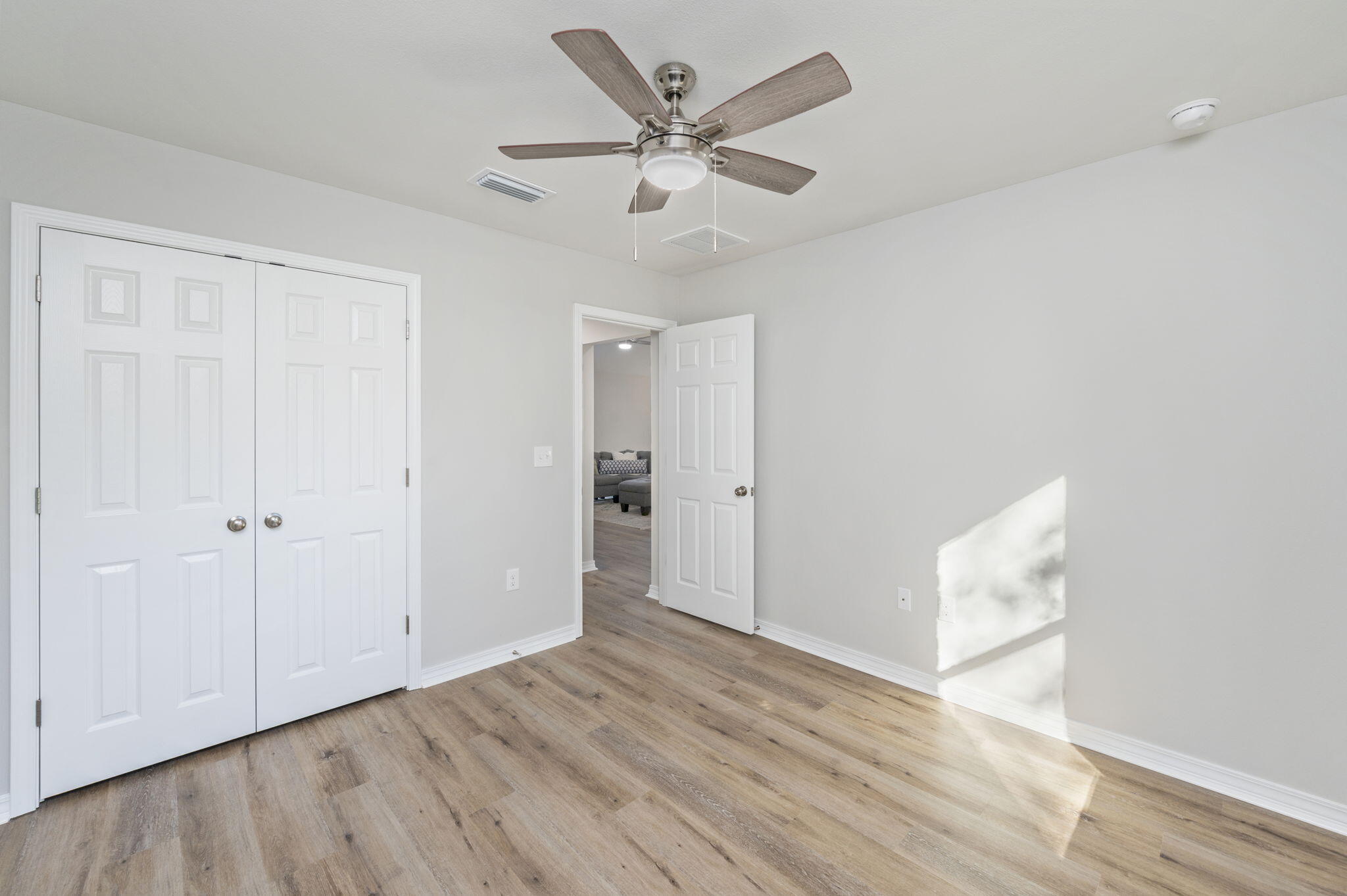1206 Sunshine Drive Crestview, FL 32539 - Photo 12 of 28 an empty room with wooden floor and ceiling fan