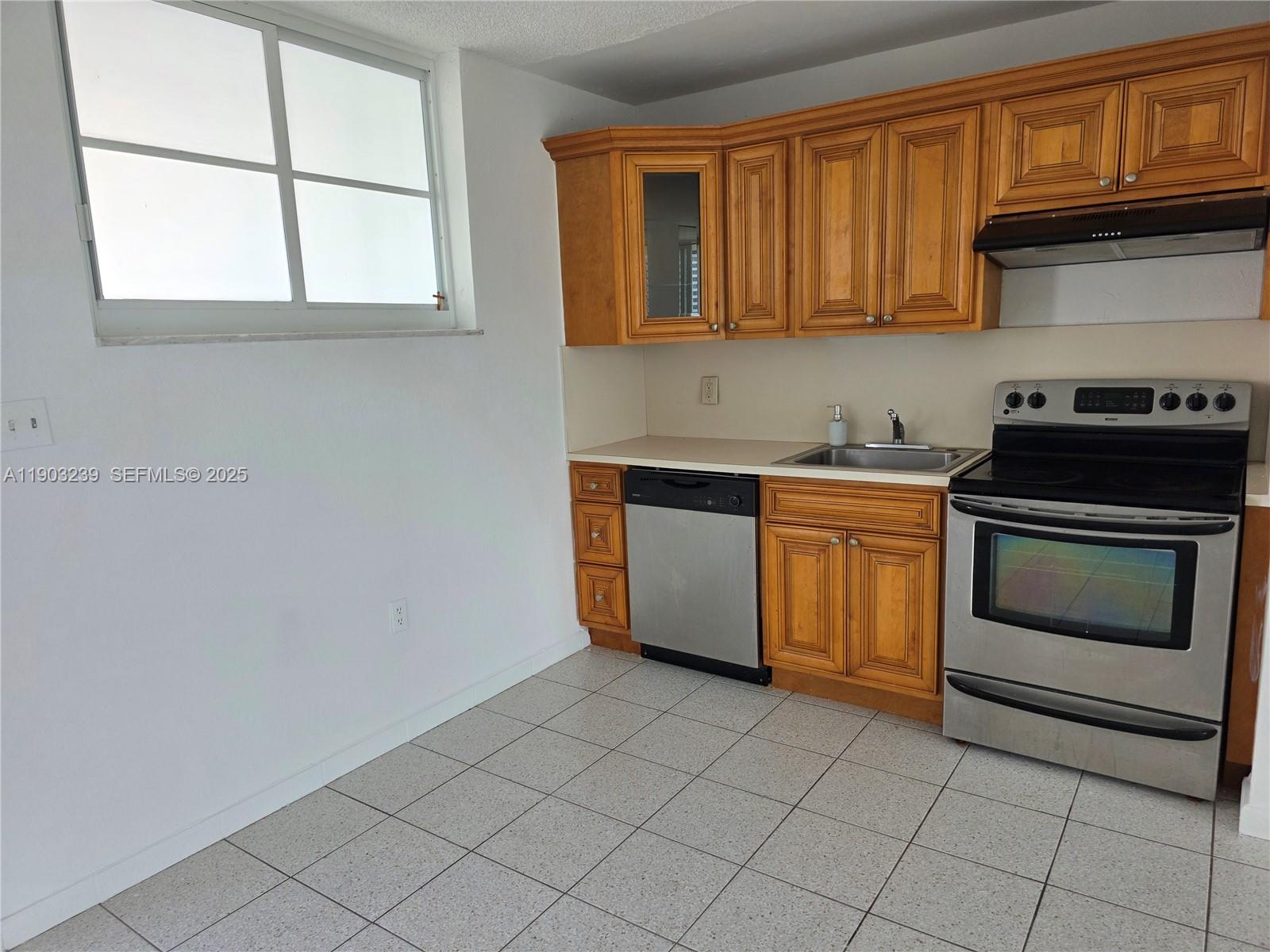 1750 James Avenue, Unit 9C Miami Beach, FL 33139 - Photo 15 of 28 a kitchen with a stove a sink and a microwave