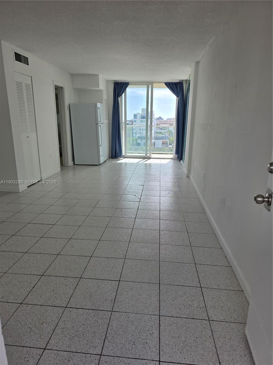 1750 James Avenue, Unit 9C Miami Beach, FL 33139 - Photo 10 of 28 an empty room with a fireplace and windows