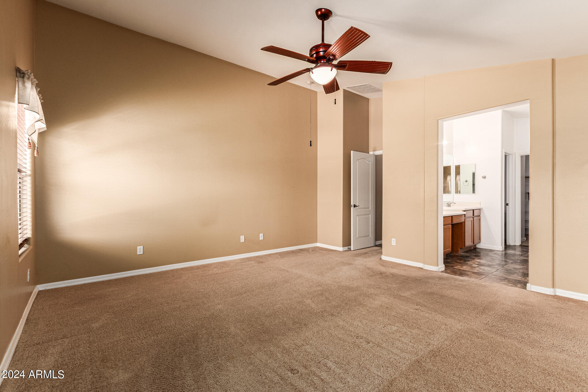 25602 West Ripple Road Buckeye, AZ 85326 - Photo 17 of 38 an empty room with a hallway and a ceiling fan