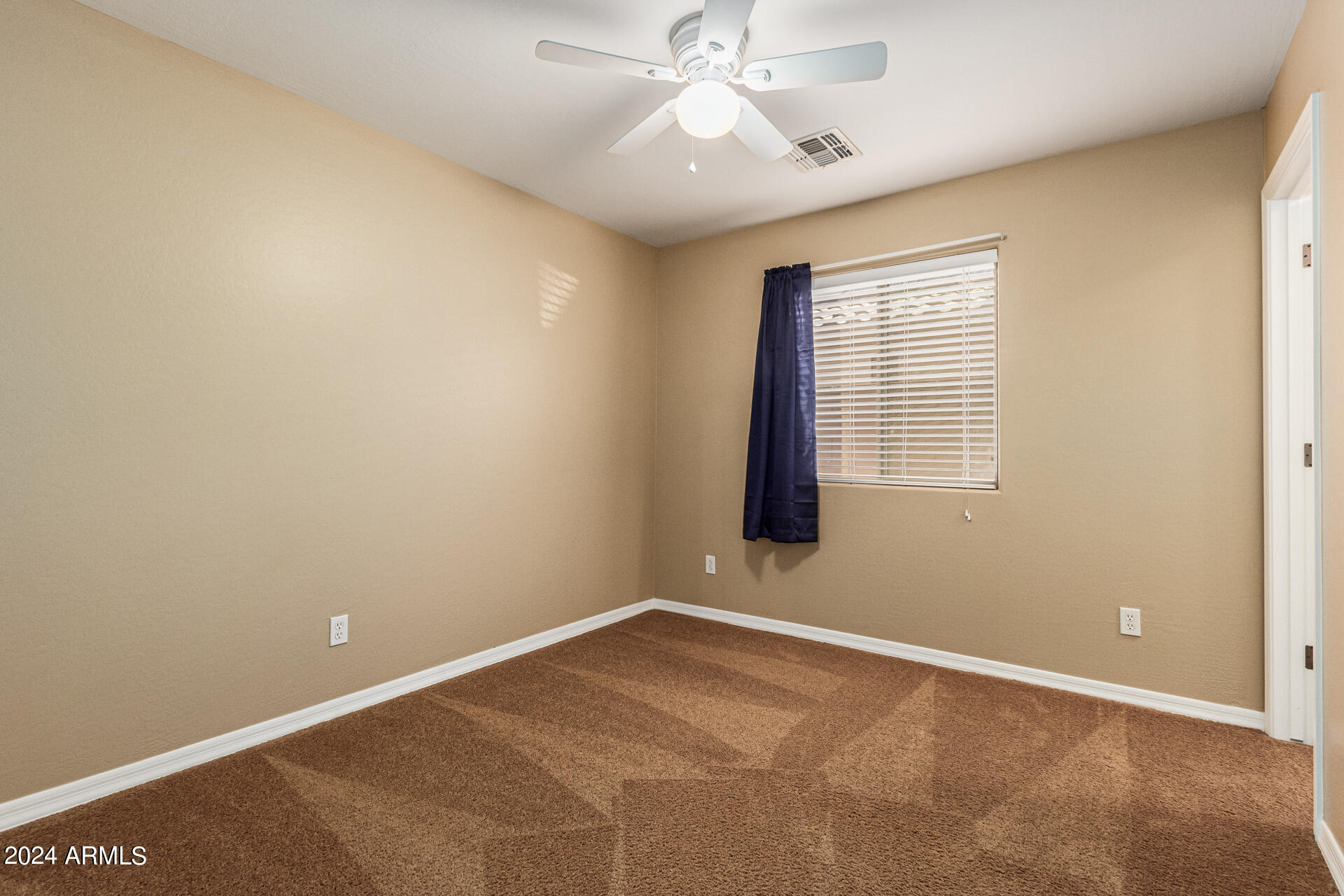 25602 West Ripple Road Buckeye, AZ 85326 - Photo 23 of 38 an empty room with a window and a fan