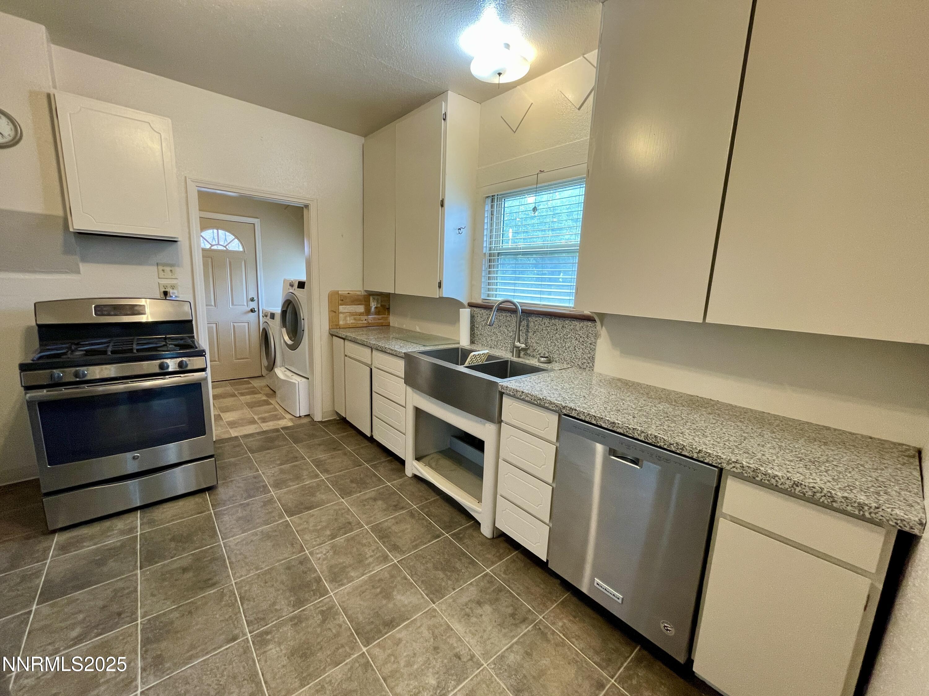 77 Lay Street Winnemucca, NV 89445 - Photo 13 of 28 a kitchen with stainless steel appliances granite countertop a stove a sink and a microwave