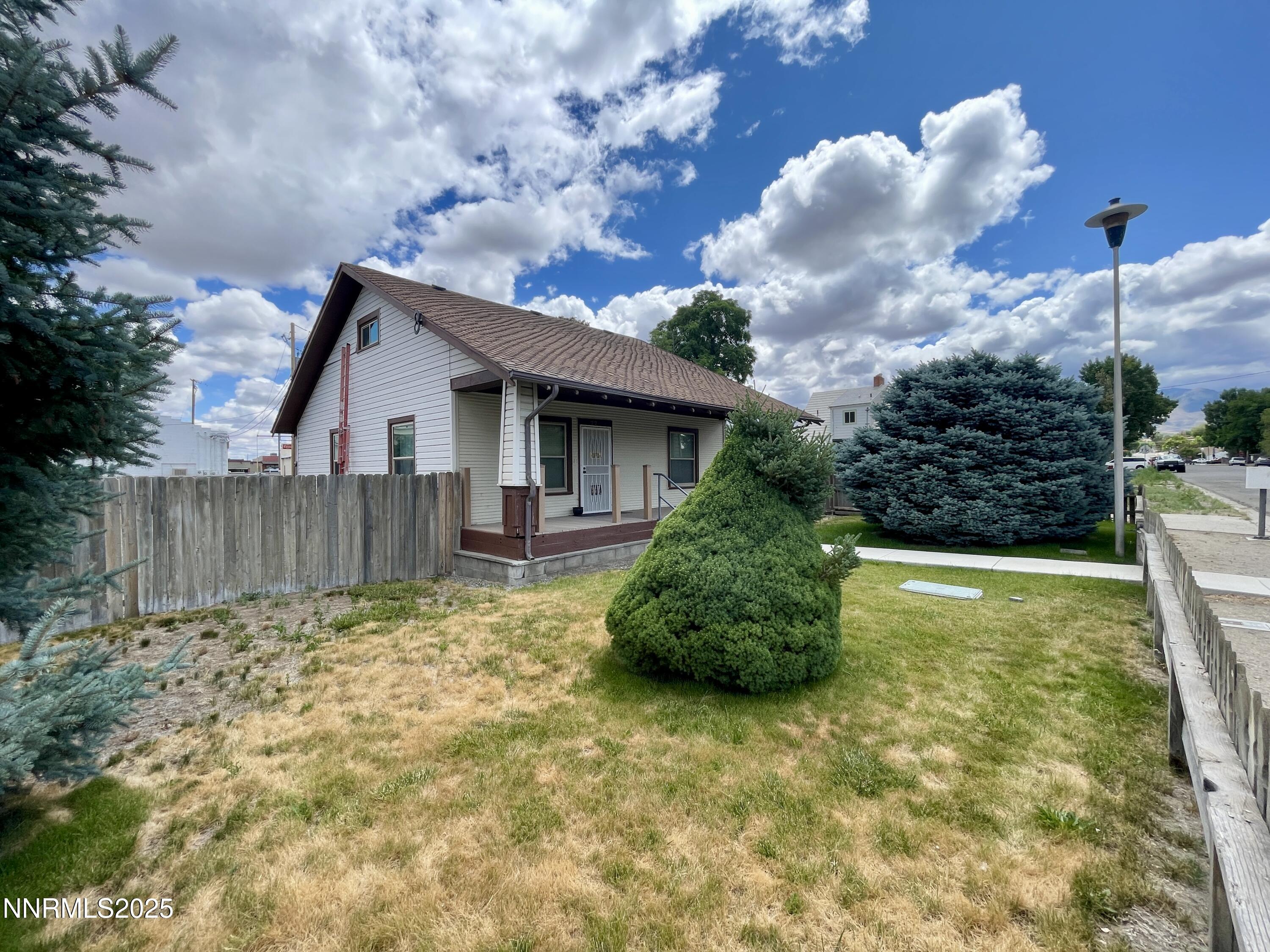 77 Lay Street Winnemucca, NV 89445 - Photo 5 of 28 a view of a backyard with wooden fence and a large tree