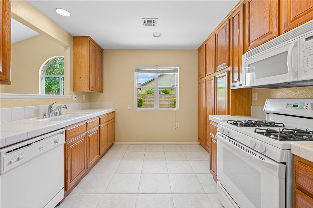 2095 Tulip Avenue Simi Valley, CA 93063 - Photo 11 of 39 a kitchen with a stove sink and cabinets