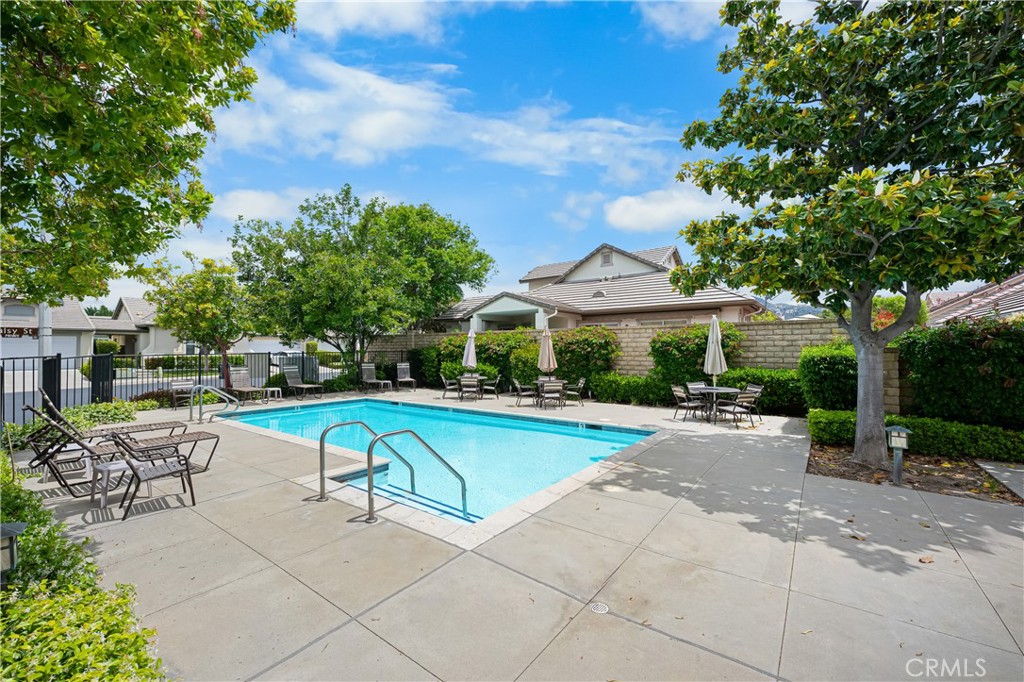 2095 Tulip Avenue Simi Valley, CA 93063 - Photo 37 of 39 a view of a swimming pool with lawn chairs under an umbrella