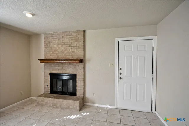 a view of an empty room with a fireplace