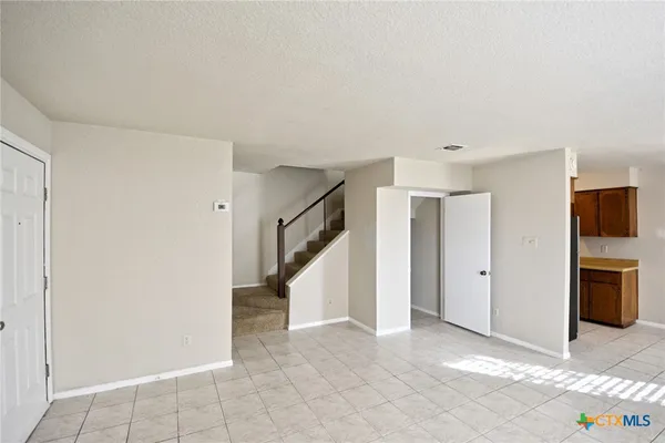 a view of an empty room with a kitchen