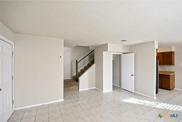 a view of an empty room with a kitchen