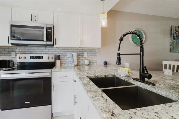 a kitchen with stainless steel appliances granite countertop a refrigerator and microwave