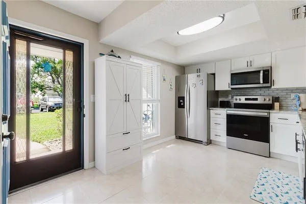 a view of living room with granite countertop kitchen island stainless steel appliances and living room view