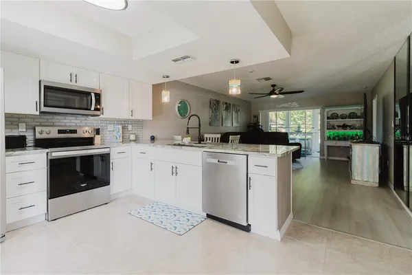 a kitchen with stainless steel appliances granite countertop a stove microwave and refrigerator