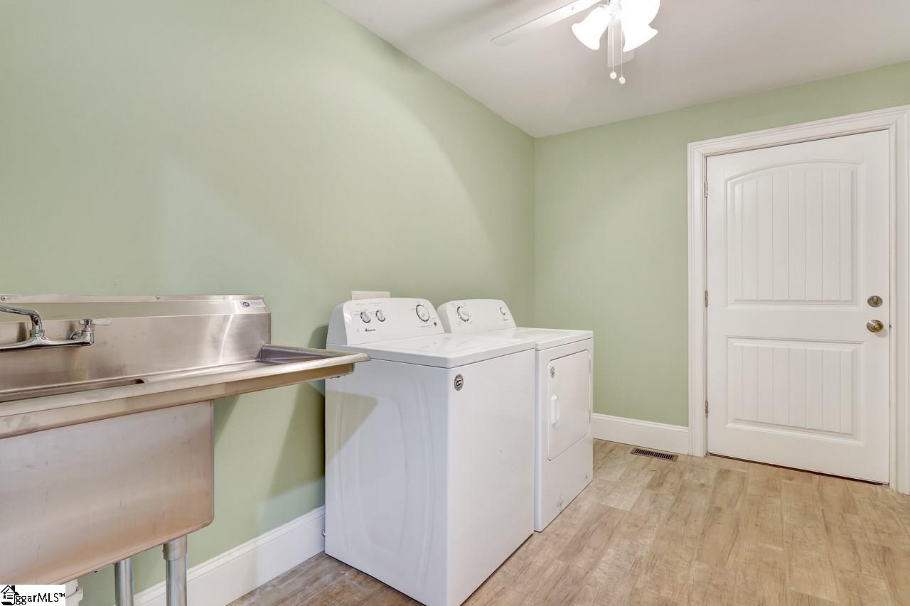 4916 State Park Road Travelers Rest, SC 29690 - Photo 32 of 34 Extra large laundry room has room for washer dryer, includes a stainless steel sink with counter, and still has plenty of room for a bench and storage, great mud room entrance from garage, with tile, to keep all the outside from getting tracked inside.