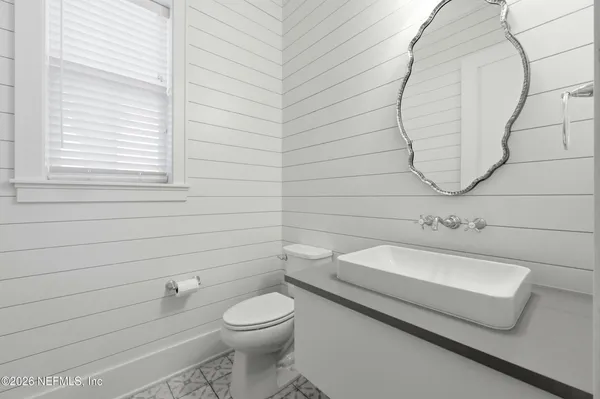 a bathroom with a toilet a sink and mirror