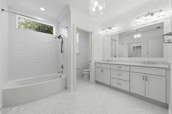 a spacious bathroom with a double vanity sink mirror and a bath tub