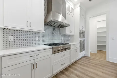 a kitchen with granite countertop white cabinets and white appliances