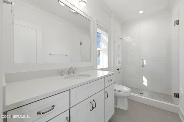 a bathroom with a granite countertop sink a toilet and shower
