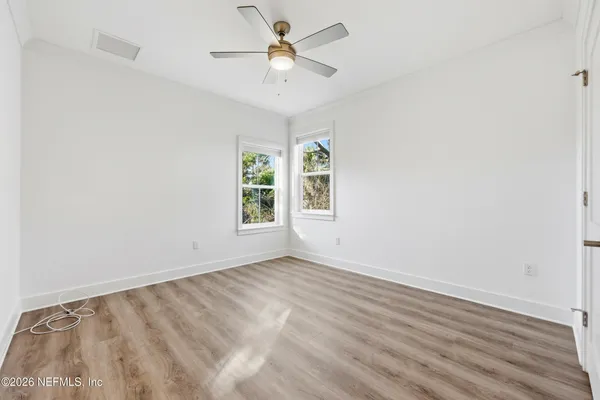 an empty room with windows and fan